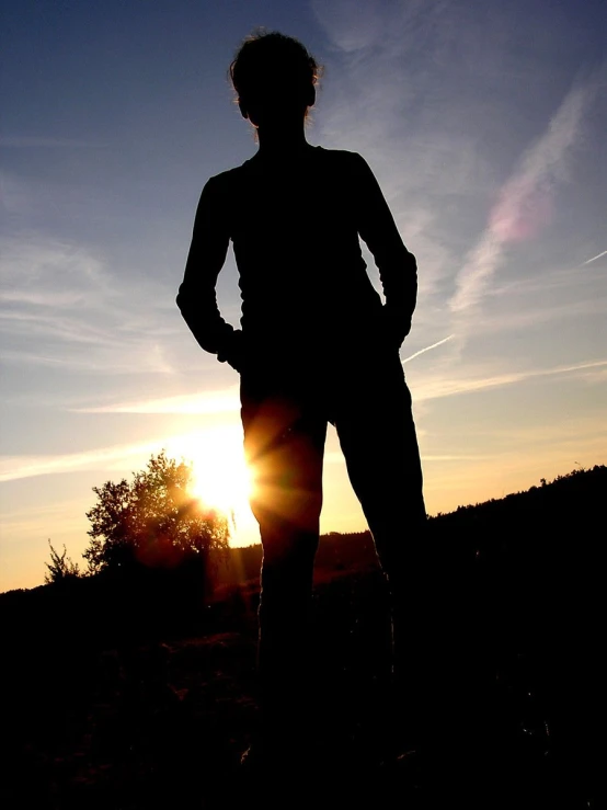 a person silhouetted against the setting sun