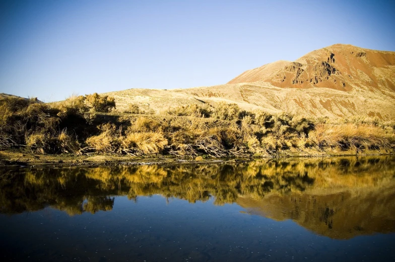 a very clear body of water near a mountain