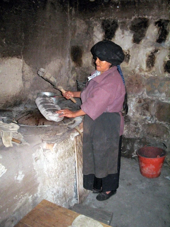 a woman in the middle of a kitchen holding a spatula