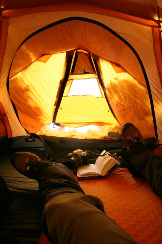 person laying in a tent with their feet up