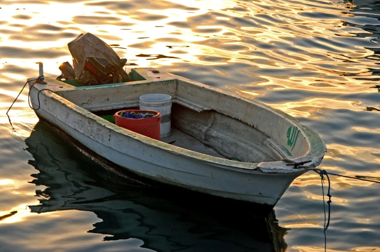 a small boat in a lake with the sun shining on water