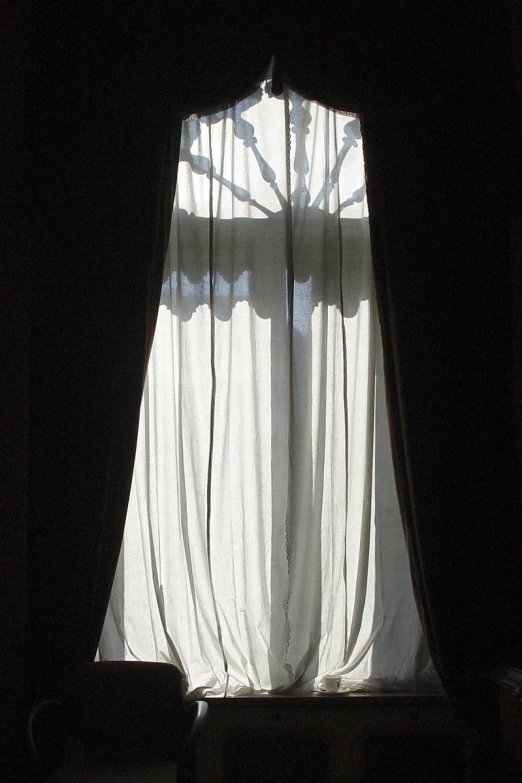 the light is shining through the curtains on the windowsill