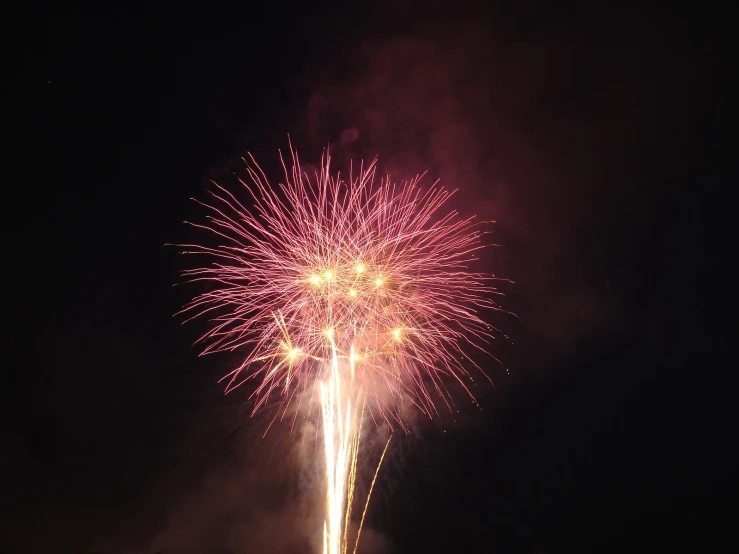 a large colorful firework in the sky above a dark background