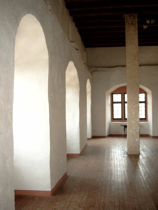 empty room with white walls and arched windows