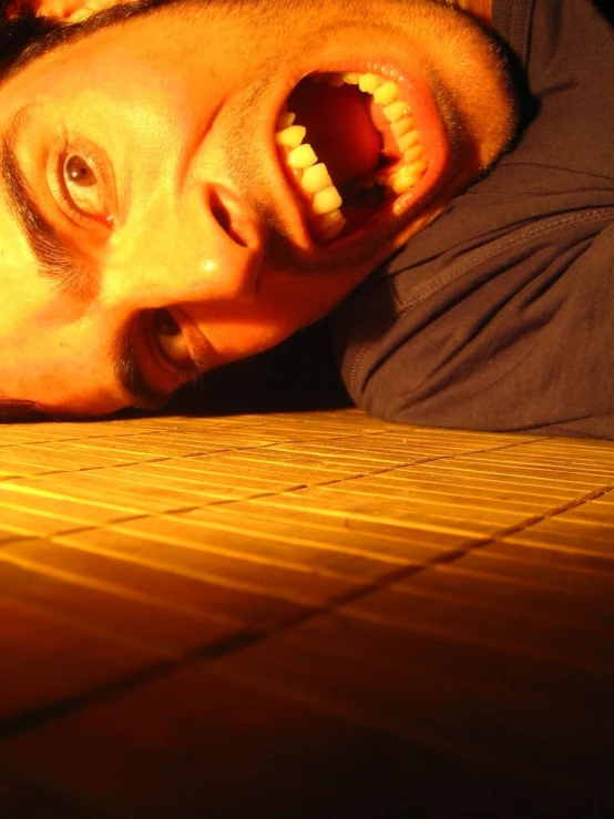 a man laying on the floor with his mouth open