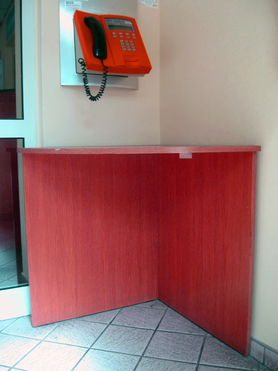 a red phone on the wall over a red counter