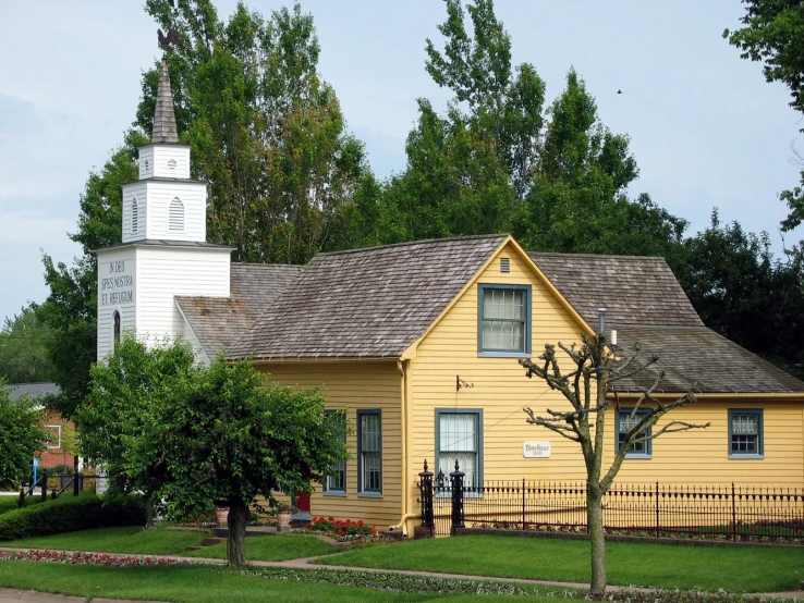 a yellow house with trees surrounding it