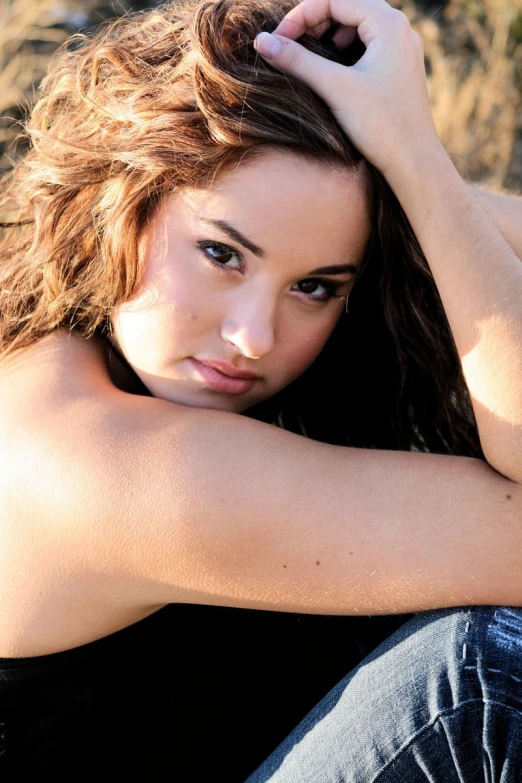 a pretty young woman sitting on the ground