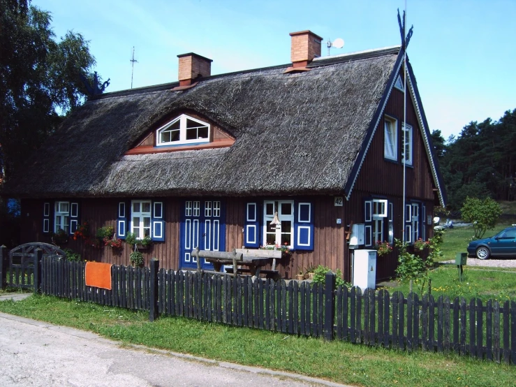 a thatched roof house with a blue door and windows
