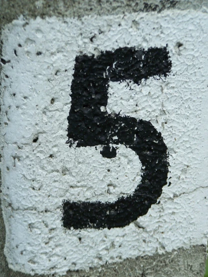 a close up of a number five on a street