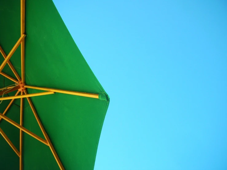 an umbrella sits high on a clear blue sky