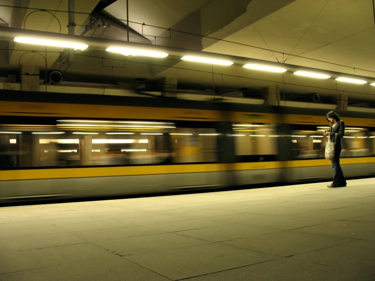 a train passes by a man in a hat at the train station