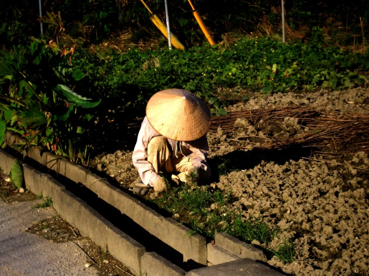 a person sitting on the ground wearing a mushroom like helmet