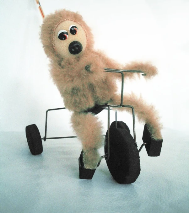 a doll sits on the wheels of a chair