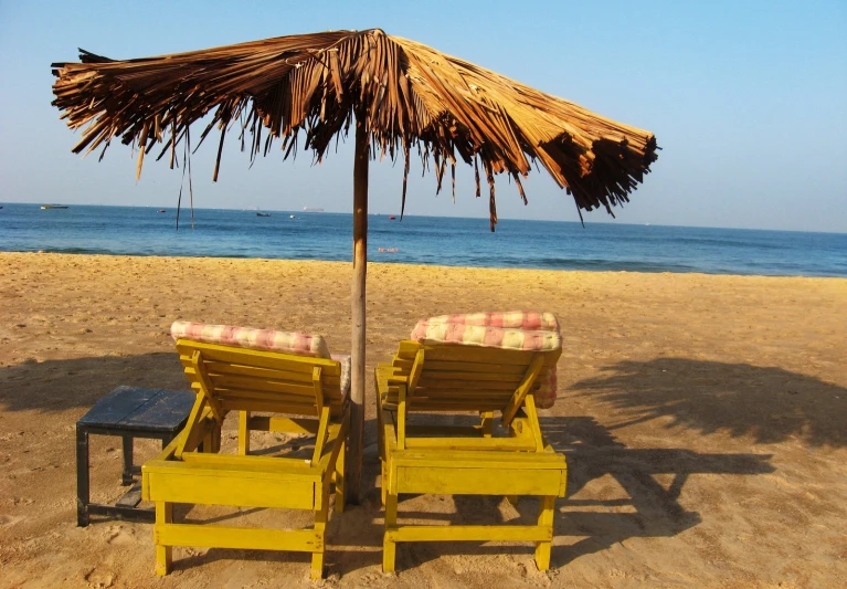 the chairs and umbrella have been placed on the beach