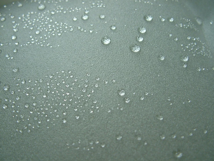 drops of water on a surface of black ink