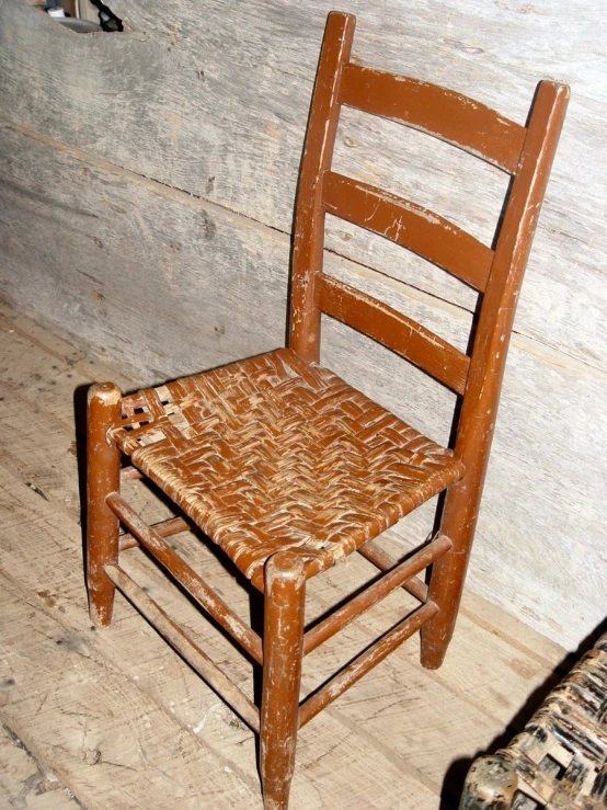 a brown chair is next to a wall