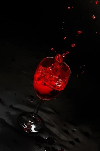 a wine glass filled with liquid on top of a black background