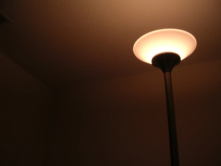an illuminated lamp in the dark above a wall