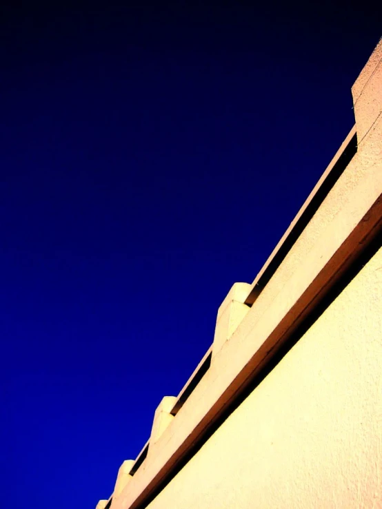 a skateboard is on the ledge of an upper portion of a building