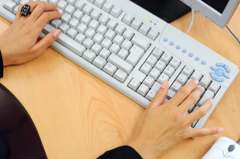 a person is typing on a keyboard near two other people