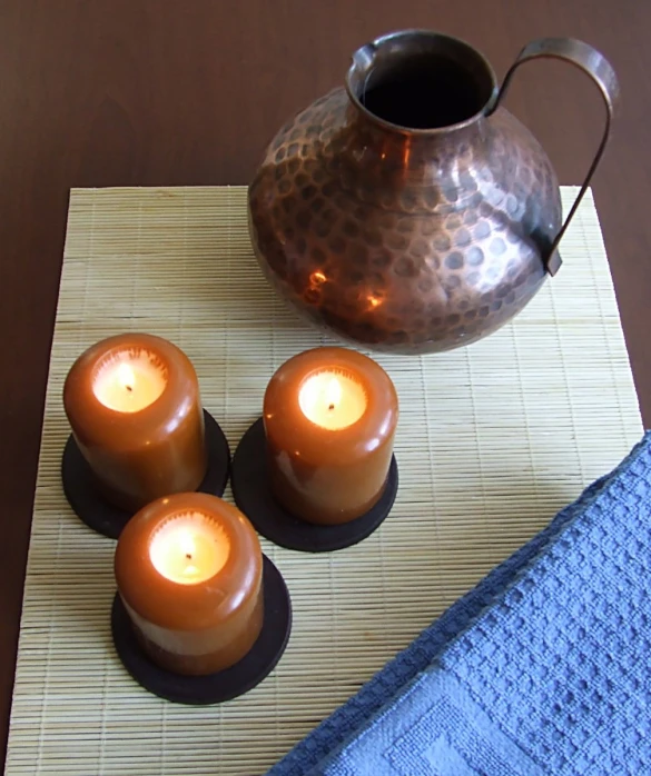 small lit candles sit on a bamboo mat