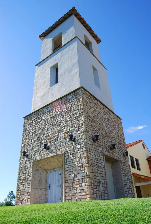 a very tall tower with a door by a building