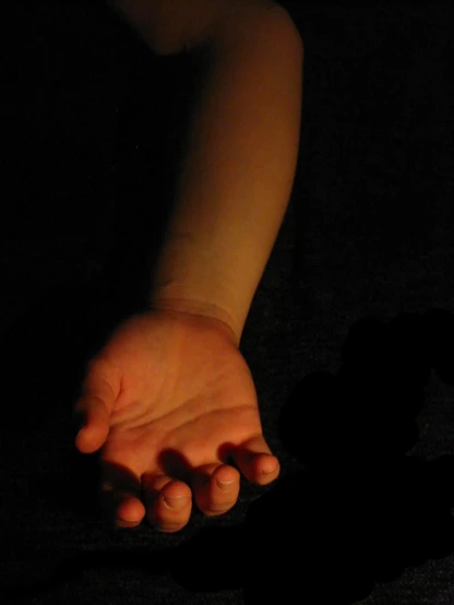 a person in the dark holding their hand out