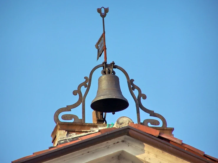 a bell atop a building with a sky in the background