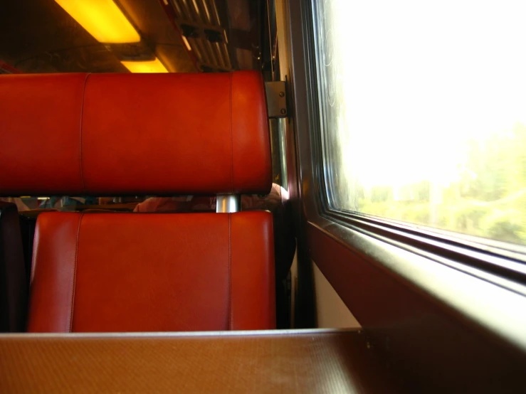 seats in the back of a train next to a window