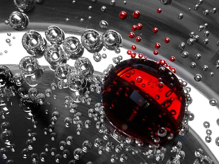 red ball is sitting inside a silver bowl