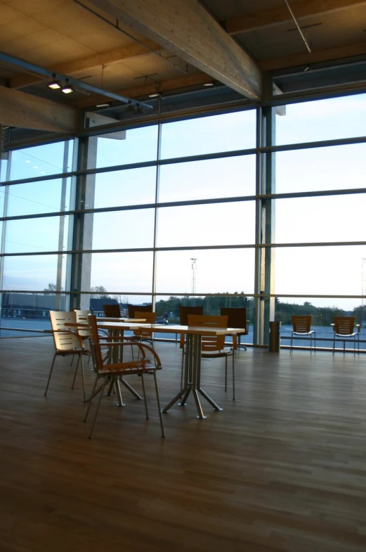 a table with chairs sitting around in front of large windows