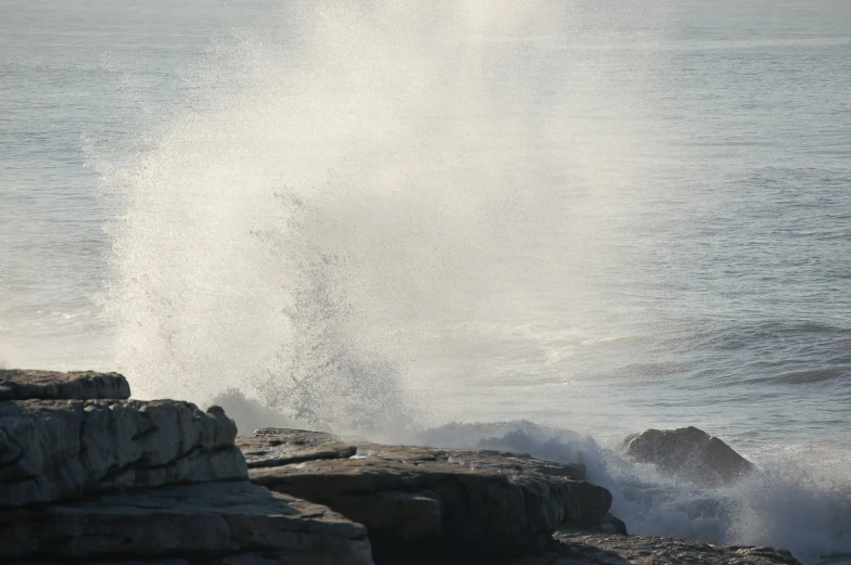 large crashing wave near rock break on the coast