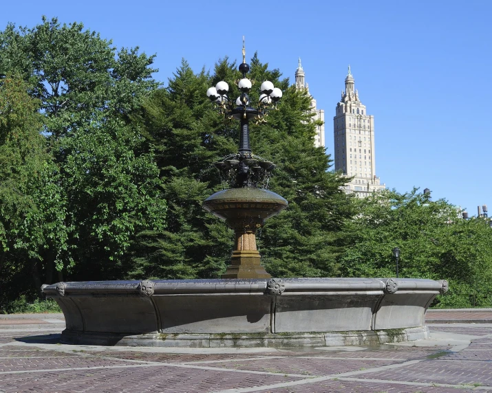 an outdoor fountain is located in the middle of a city square