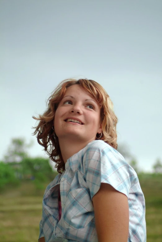 a woman who is smiling with the sky in the background