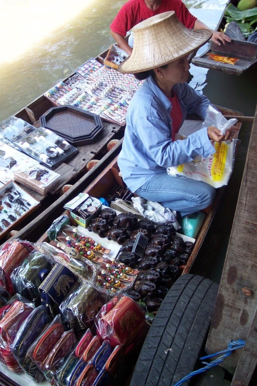 a man and a woman selling goods in a boat