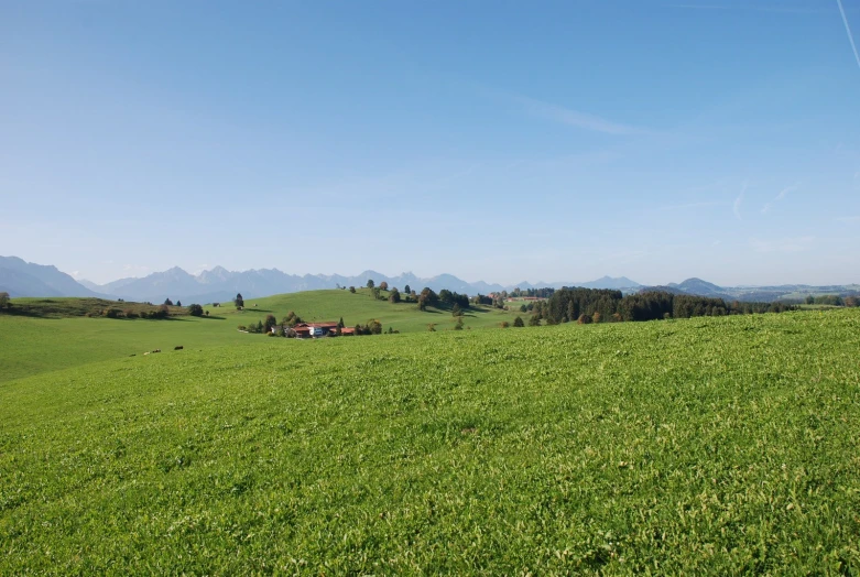 the mountains with hills in the distance are covered in grass