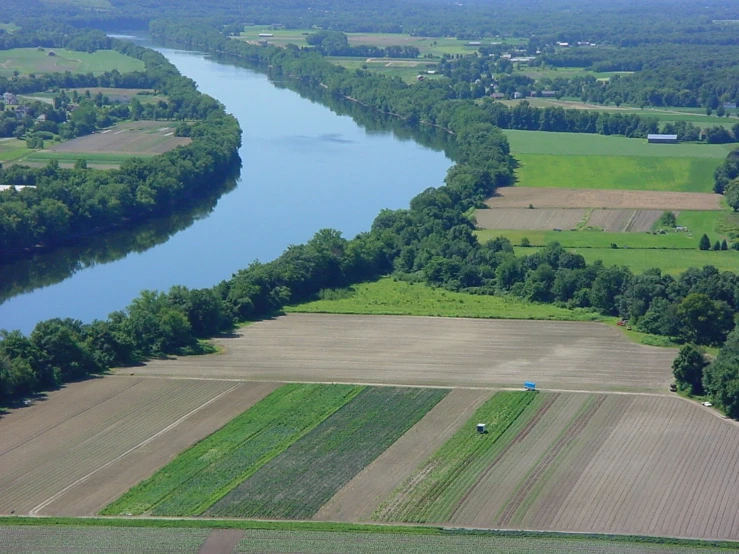 an aerial view of a field with trees and river