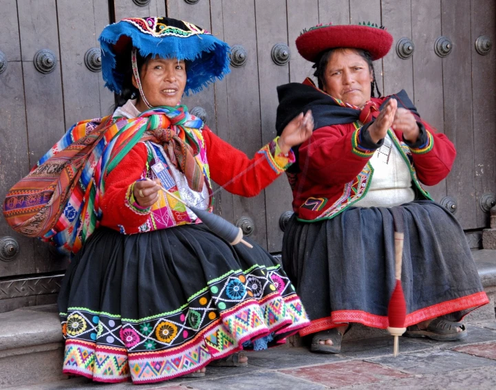 two women in mexican dress sitting on the ground