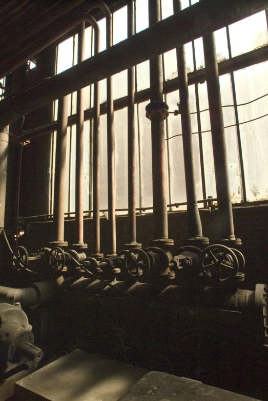 several water pipes are next to a window in the building