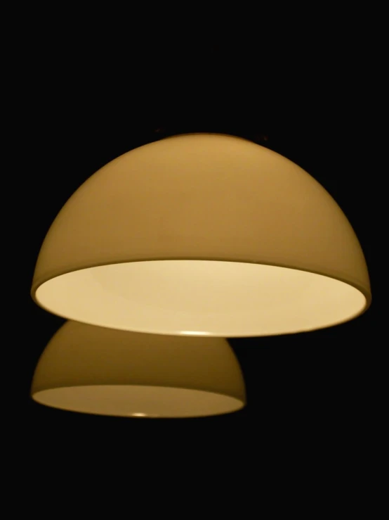 a circular light hangs in the dark room
