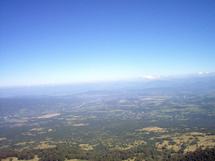 the landscape from above shows the valley and distant land