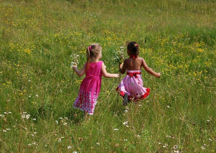 two little girls in flower field playing with balloons