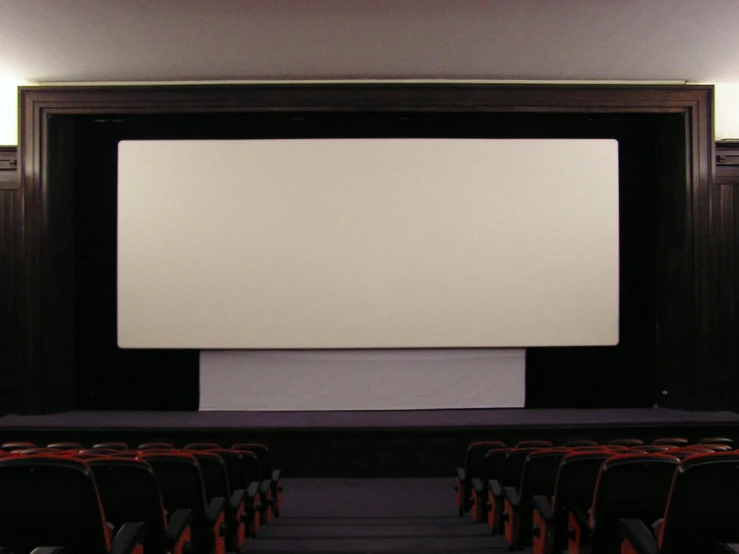 an empty screen in front of the seats at a theater