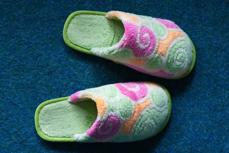 a pair of colorful slippers laying on top of a carpet