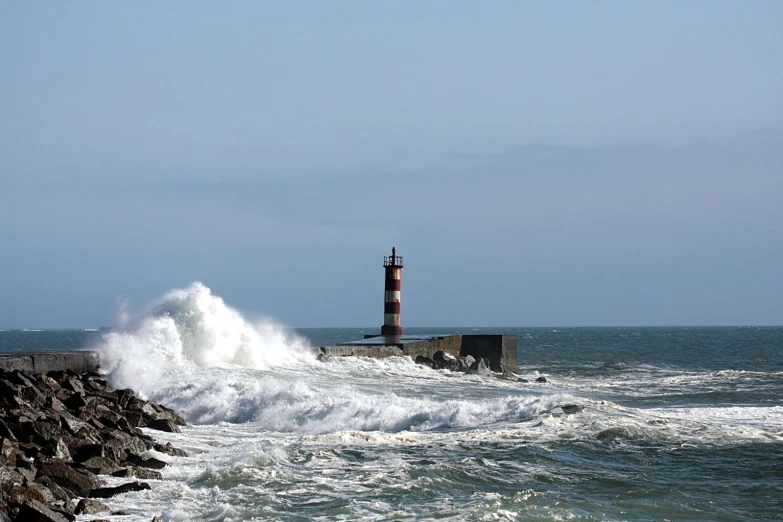 a light house sitting on top of a rocky cliff next to the ocean