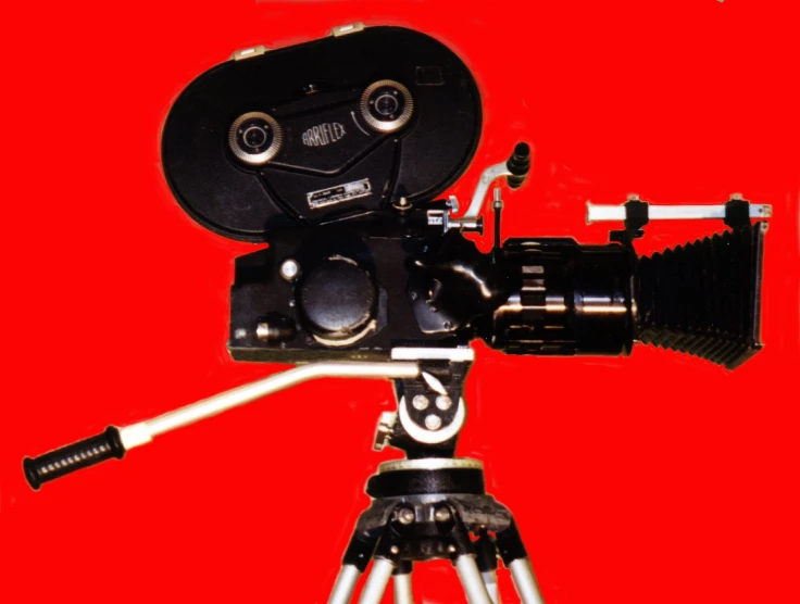 old movie camera being used on red background