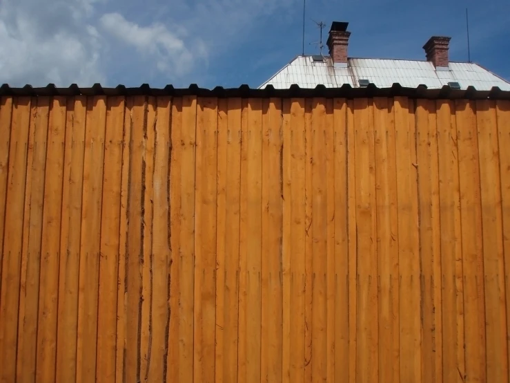 a cat is sitting on a step by the fence