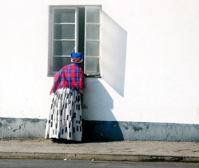 a man standing by the side of a building