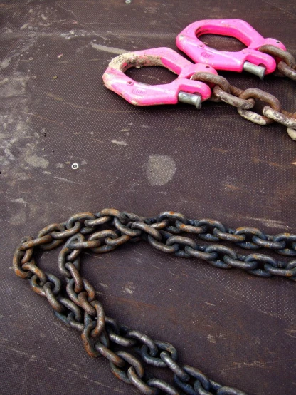 two pink handles on chains are  to each other